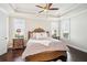 Comfortable bedroom featuring hardwood floors, a tray ceiling, and a cozy ambiance at 4155 Brookview Dr, Cumming, GA 30040