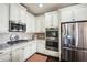 Modern kitchen with stainless steel appliances, granite countertops, and white cabinetry at 4155 Brookview Dr, Cumming, GA 30040