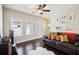 Comfortable living room featuring dark hardwood floors, bright windows, and a plush leather sofa at 4155 Brookview Dr, Cumming, GA 30040