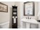 Charming half-bathroom featuring pedestal sink and decorative storage cabinet with shelves at 4155 Brookview Dr, Cumming, GA 30040