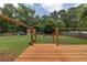 Wide backyard view featuring a fire pit, chicken coop, play area, and a wooden deck at 5 White Pines Dr, Dallas, GA 30157