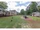 View of large grassy backyard, deck, patio with fire pit, playset, chicken coop and a few chickens at 5 White Pines Dr, Dallas, GA 30157