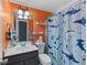 Orange bathroom with a shark-themed shower curtain and a single sink vanity at 5 White Pines Dr, Dallas, GA 30157
