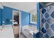 Bright blue bathroom with a tub, shower, and view into the main bedroom at 5 White Pines Dr, Dallas, GA 30157