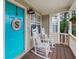 Cozy front porch with rocking chairs, a blue door with décor, and wood flooring at 5 White Pines Dr, Dallas, GA 30157