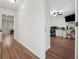 Hallway with wood floors that leads to a bright home office with modern desk setup at 950 Ivy St, Cumming, GA 30041