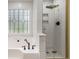 Bathroom with a bathtub and shower, modern tile, and bronze fixtures at 108 Faraday Dr, Douglasville, GA 30134