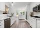 Bright kitchen features white cabinetry, stainless steel appliances, and hardwood floors at 108 Faraday Dr, Douglasville, GA 30134