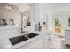 Bright kitchen featuring white cabinets, stainless steel sink, and marble countertops at 108 Faraday Dr, Douglasville, GA 30134
