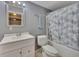 Clean bathroom with a vanity, commode, and tub shower with attractive shower curtain at 2018 Township Dr, Woodstock, GA 30189