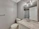 This bathroom features a marble-top vanity and a glass-enclosed shower, with neutral grey walls at 2018 Township Dr, Woodstock, GA 30189