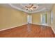 This home's bright bedroom features hardwood floors, yellow walls, and a ceiling fan at 2018 Township Dr, Woodstock, GA 30189