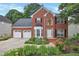 Charming brick home featuring a two-car garage, manicured landscaping, and a welcoming front entrance at 2018 Township Dr, Woodstock, GA 30189
