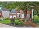 Traditional brick home featuring an American flag, a well-maintained lawn, and colorful flower beds at 2018 Township Dr, Woodstock, GA 30189