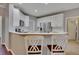 Open kitchen features white cabinets, stainless appliances, and breakfast bar seating at 2018 Township Dr, Woodstock, GA 30189