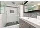 This renovated bathroom features a glass shower with white and gray tile next to a dual sink vanity at 677 Holmes Nw St, Atlanta, GA 30318