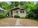 Charming bungalow with light green siding, stone walkway, and mature trees at 677 Holmes Nw St, Atlanta, GA 30318