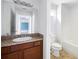 Bathroom featuring a vanity with dark wood cabinetry and a view into the bathtub and toilet at 6770 Gordon Manor Sw Ct, Mableton, GA 30126
