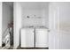 Bright laundry room featuring a washer and dryer set, with white walls and shelving for storage at 6770 Gordon Manor Sw Ct, Mableton, GA 30126