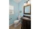 Cozy half bathroom featuring a granite countertop, decorative mirror, and ample natural light at 10735 Pinewalk Forest Cir, Alpharetta, GA 30022