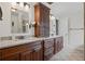 Bathroom featuring double vanity with granite countertops, custom cabinetry, and contemporary fixtures at 10735 Pinewalk Forest Cir, Alpharetta, GA 30022