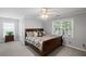 Bright bedroom features a ceiling fan, two large windows, and comfortable carpeting at 10735 Pinewalk Forest Cir, Alpharetta, GA 30022