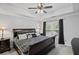 Comfortable bedroom featuring a tray ceiling, large windows, and dark wooden furniture at 10735 Pinewalk Forest Cir, Alpharetta, GA 30022