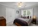 Cozy bedroom with natural lighting, a bed with plaid bedding, a ceiling fan, and storage spaces at 10735 Pinewalk Forest Cir, Alpharetta, GA 30022