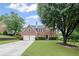 Traditional brick home featuring a well-manicured lawn and an attached two-car garage at 10735 Pinewalk Forest Cir, Alpharetta, GA 30022