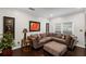 Inviting living room featuring a comfortable sectional sofa, wood floors, and a large window at 10735 Pinewalk Forest Cir, Alpharetta, GA 30022