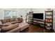 Comfortable living room featuring a sectional sofa, dark wood floors, and ample natural light at 10735 Pinewalk Forest Cir, Alpharetta, GA 30022