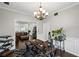 Charming office with a chandelier, large desk, and visible living room access for easy work/life balance at 10735 Pinewalk Forest Cir, Alpharetta, GA 30022