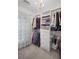 Well-organized walk-in closet featuring built-in shelving, hanging rods, and a stylish chandelier at 10735 Pinewalk Forest Cir, Alpharetta, GA 30022