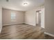 This bedroom is spacious with neutral tones, wood flooring, a window, and access to a hallway and other rooms at 1501 Buckingham, Stockbridge, GA 30281