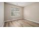 Neutral bedroom featuring vinyl flooring, light-colored walls, and window with blinds to filter natural light at 1501 Buckingham, Stockbridge, GA 30281