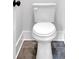 Modern white toilet with dark grey floor tiles and white baseboards at 152 Palisade Dr, Rydal, GA 30171