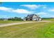 Spacious front lawn of a modern farmhouse with a long driveway and picturesque countryside views at 152 Palisade Dr, Rydal, GA 30171