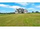 Expansive front lawn of a modern farmhouse with countryside and wooded area in the background at 152 Palisade Dr, Rydal, GA 30171