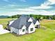 Two-story home with an attached garage, lush lawn, and mountain views in the background at 152 Palisade Dr, Rydal, GA 30171