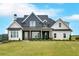 Striking two-story home featuring a modern farmhouse design with a covered front porch and expansive lawn at 152 Palisade Dr, Rydal, GA 30171
