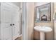 Stylish half-bathroom featuring a pedestal sink, decorative mirror and storage at 2804 Stillwater Park Dr, Marietta, GA 30066