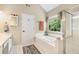 Bright bathroom featuring a soaking tub next to a window and glass-enclosed shower at 2804 Stillwater Park Dr, Marietta, GA 30066