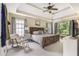 Spacious main bedroom with tray ceiling, ceiling fan, and rocking chair near windows at 2804 Stillwater Park Dr, Marietta, GA 30066