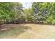 Large grassy backyard is surrounded by mature trees and a wood fence at 3404 Broxton Mill Way, Snellville, GA 30039