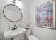 Stylish powder room features pedestal sink, round mirror and lovely artwork at 70 Old Ivy Ne Rd # 57, Atlanta, GA 30342