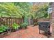 Private brick patio with lush landscaping, brick privacy wall, and outdoor grill at 70 Old Ivy Ne Rd # 57, Atlanta, GA 30342