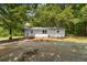 Charming single-story home exterior with white siding surrounded by mature trees at 2871 Tucker Mill Sw Rd, Conyers, GA 30094