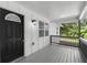 Covered front porch with black front door, white columns, and gray railings at 2871 Tucker Mill Sw Rd, Conyers, GA 30094