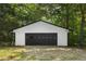 A modern, detached garage with a black door and white exterior siding at 2871 Tucker Mill Sw Rd, Conyers, GA 30094