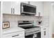 Close up on stainless range and microwave with white countertops, cabinetry and modern hardware at 2871 Tucker Mill Sw Rd, Conyers, GA 30094